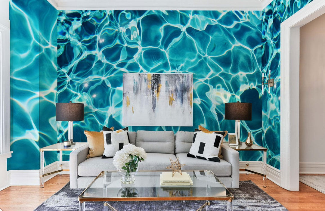Turquoise ripple wallpaper in stylish living room with grey sofa, abstract art, and wooden flooring.