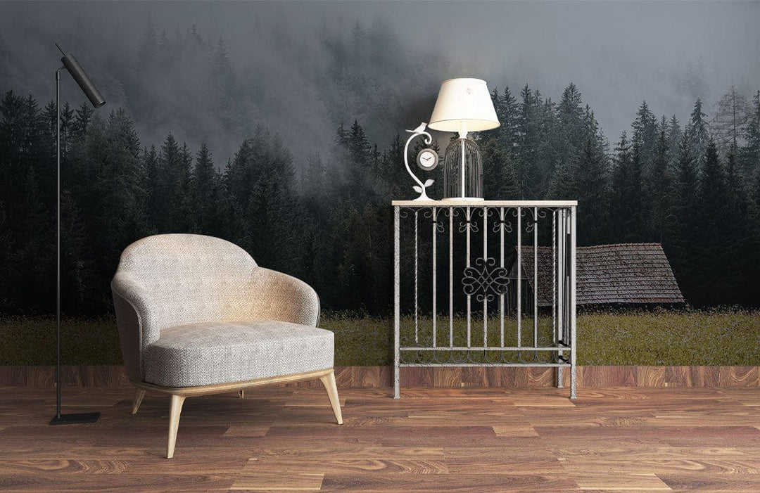 Rustic forest mural wallpaper with grey armchair, metal side table, and wooden flooring in living room.
