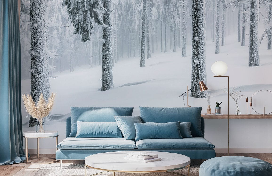 Snowy Winter Forest mural wallpaper with grey tones, blue sofa, wooden flooring, modern living room decor.