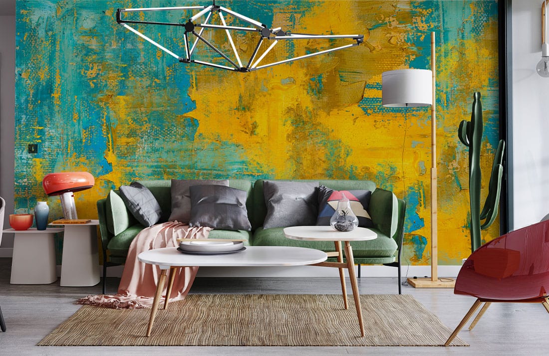 Colourful abstract teal yellow mural wallpaper with green sofa, modern lighting, rug, and coffee tables.