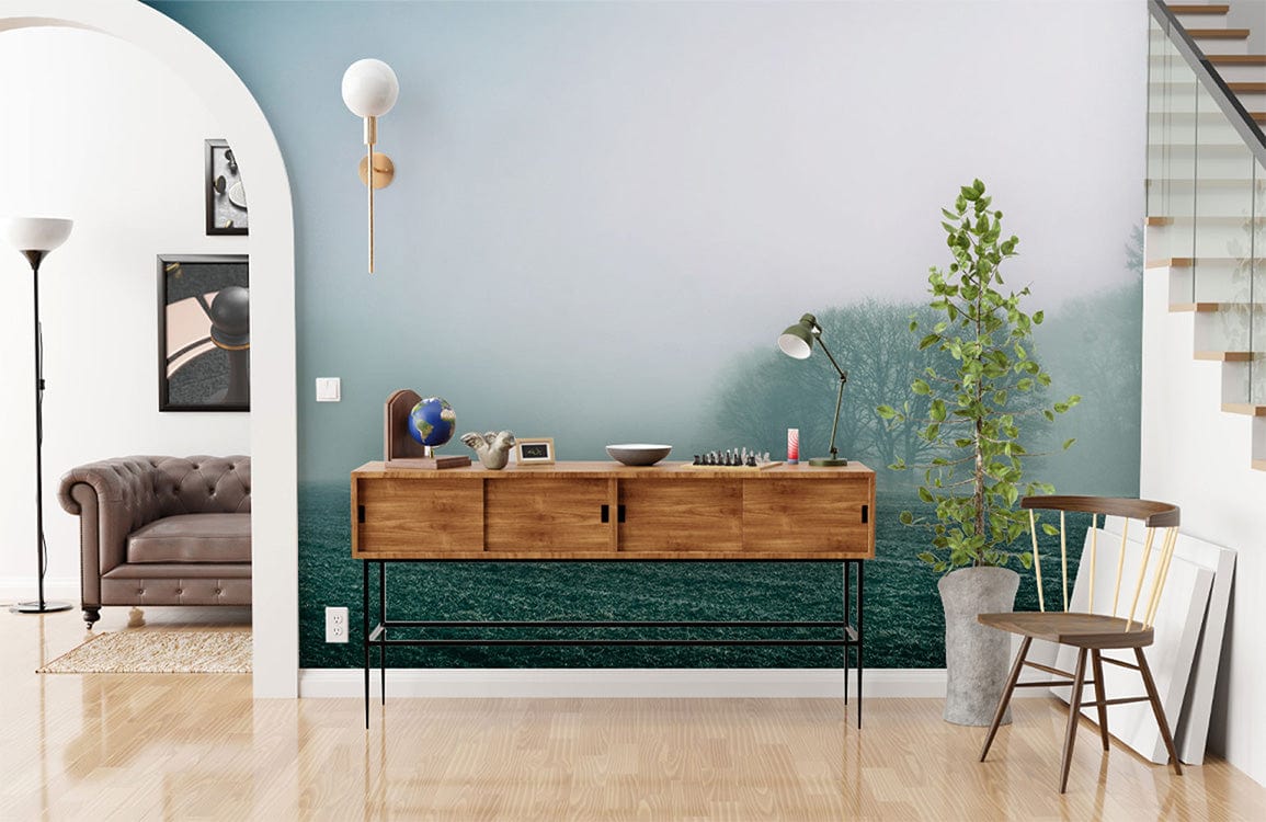 Misty Morning Landscape Mural Wallpaper with serene hues, brown sofa, wooden flooring, and archway door.
