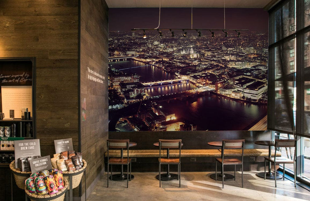 London night skyline mural wallpaper, modern café setting, wooden walls, concrete flooring, stylish seating.