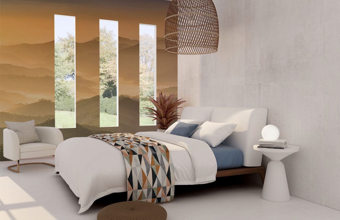Tranquil Sunrise Mist Mountain Mural Wallpaper with white modern bed, geometric throw, beige armchair, pendant.