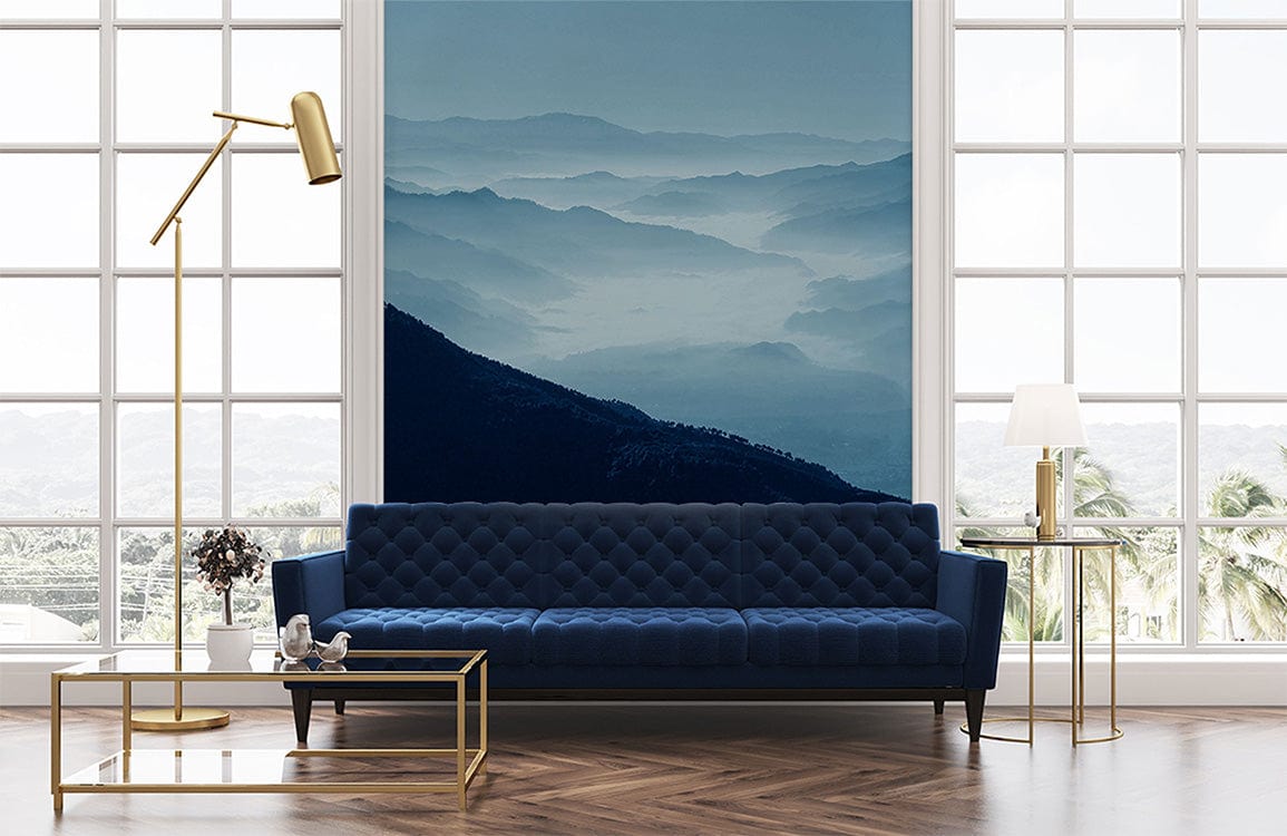 Blue Misty Mountains mural in living room with blue sofa, gold lamp, and parquet flooring.