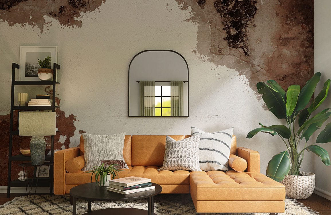 Rustic Earthy Tones Abstract Mural Wallpaper in living room with tan sofa, modern mirror, wood floors.