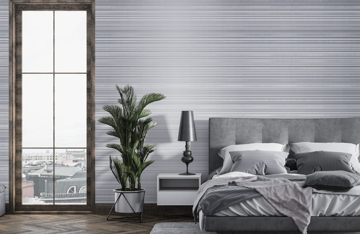 Elegant grey striped modern mural wallpaper in bedroom with grey bed, wooden floor, and tall window.