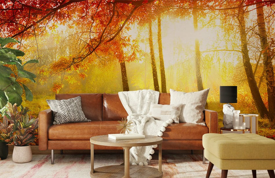 Sunlit Autumn Forest Mural Wallpaper, cosy brown leather sofa, round wooden coffee table, warm decor.