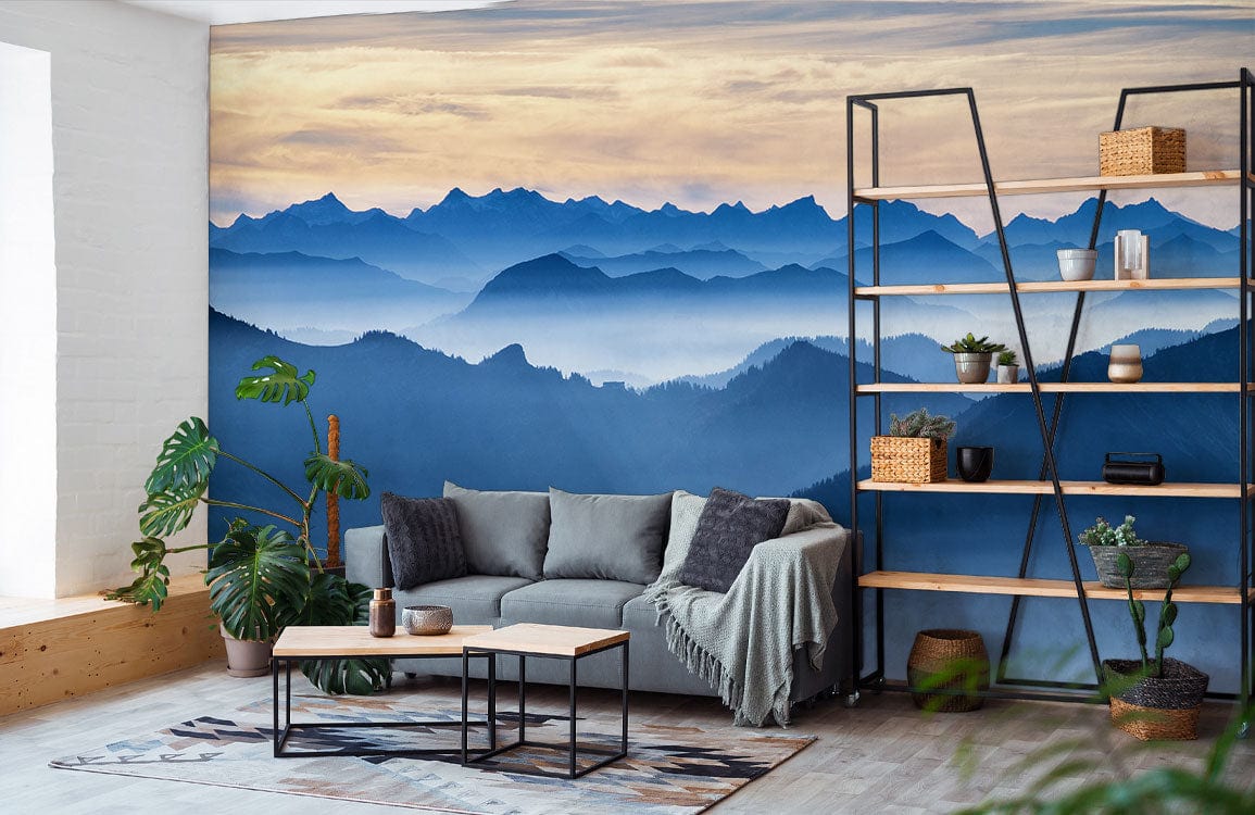 Modern living room with Serene Blue Mountain Mural, grey sofa, wooden flooring, black shelf, plants.