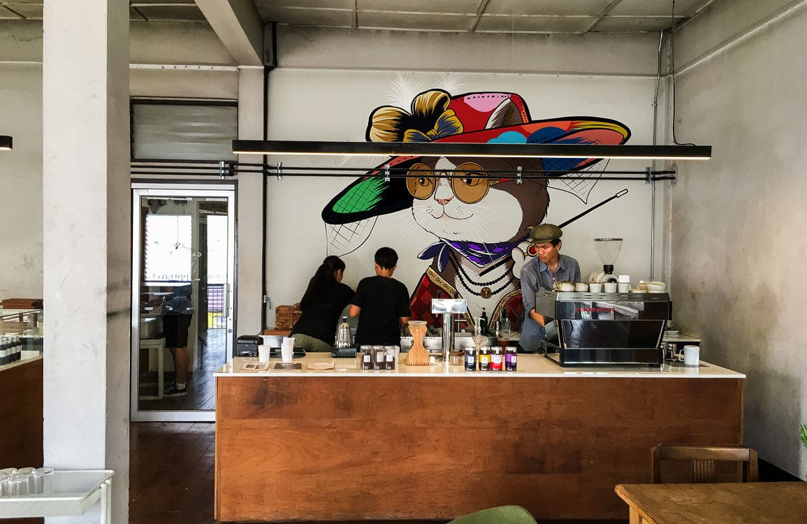 Chic Cat in Colourful Hat mural wallpaper, vintage style, café setting, wooden counter, modern Décor.