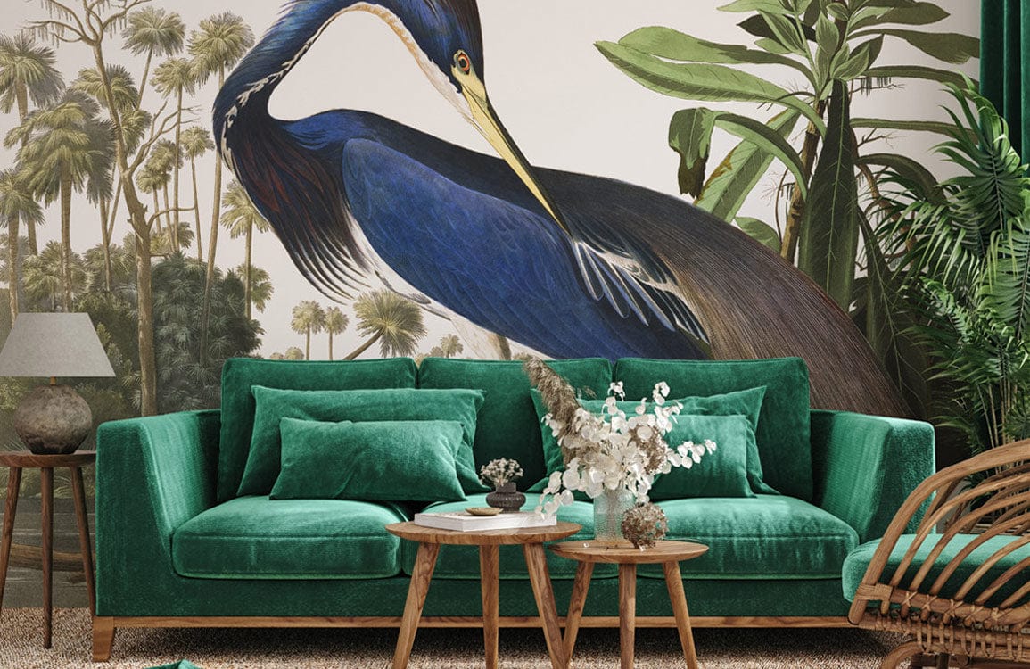 Elegant Blue Heron mural wallpaper, home interior with green velvet sofa, tropical accents, wooden flooring.