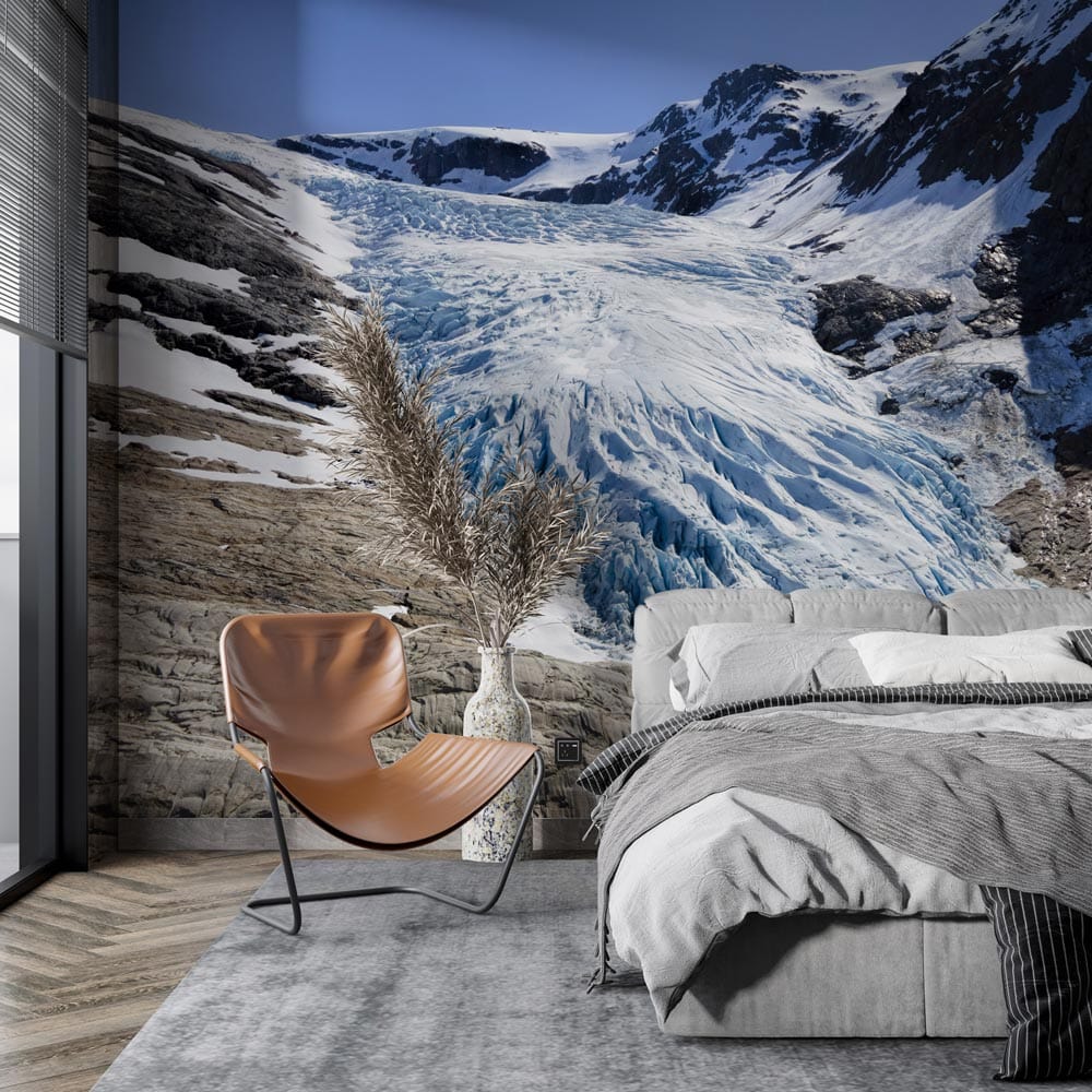 Majestic Glacier Mural Wallpaper; blue and grey tones; modern bedroom; brown chair; grey bedspread.