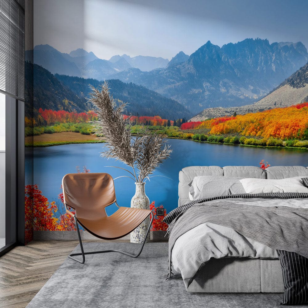 Vibrant autumn mountain lake mural wallpaper with grey sofa, wooden chair, grey carpet in living room.