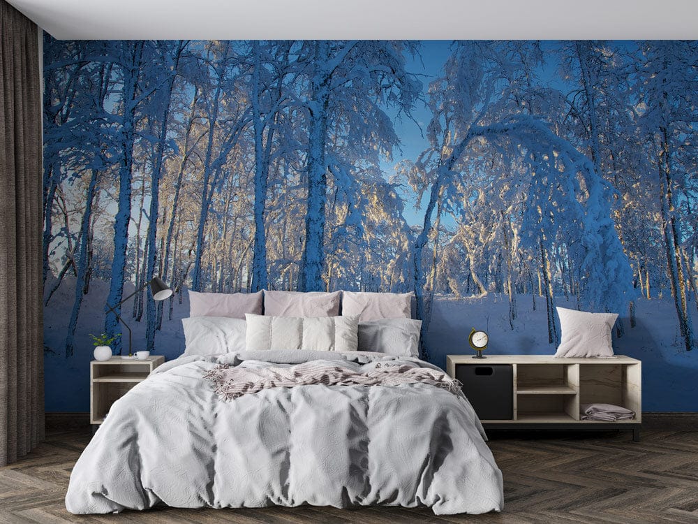 Enchanting Winter Wonderland Snowy Forest Mural Wallpaper in blue hues, bedroom setting, grey bed, wood flooring.