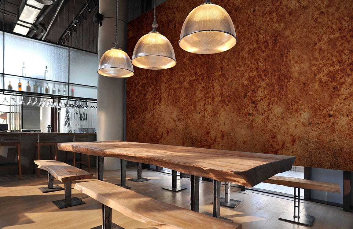 Industrial dining room with wooden tables, benches, pendant lights, and Vintage Rust Effect Textured Brown Mural Wallpaper.