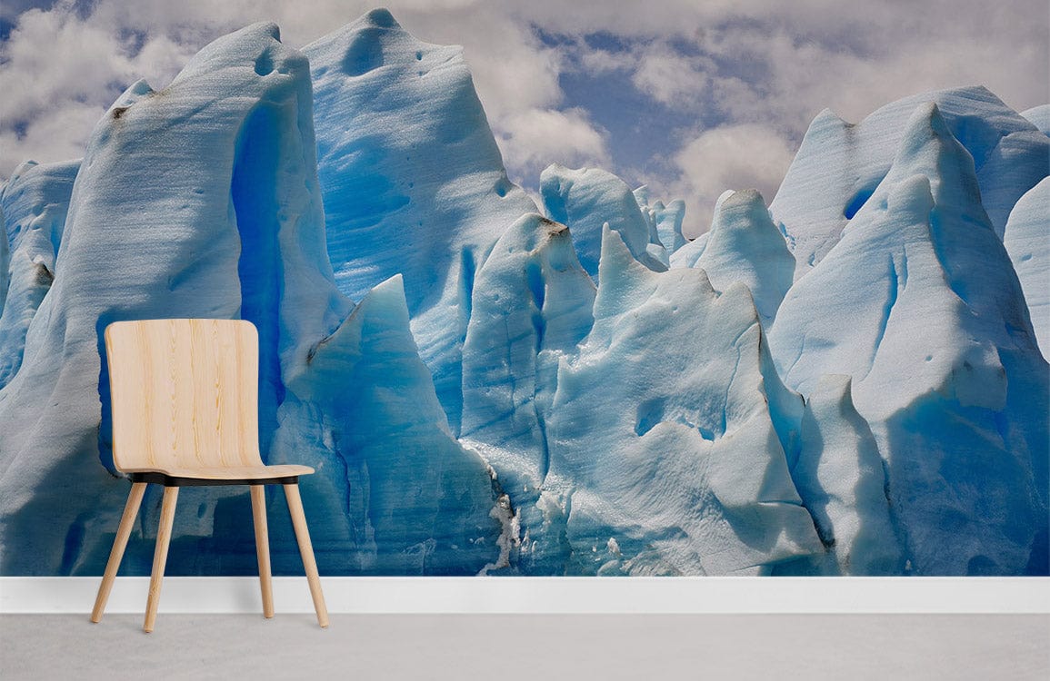 Icy Blue Glacier Mural Wallpaper in modern room with light wood chair and grey flooring.