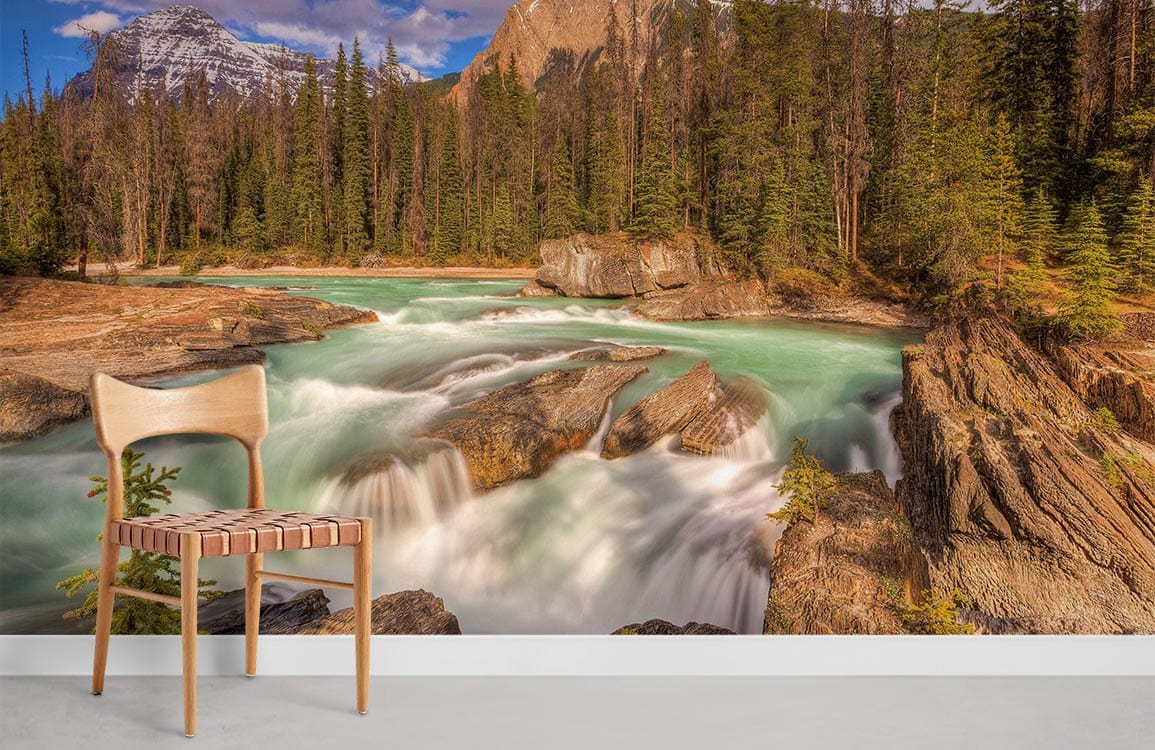 Majestic mountain river mural in earthy tones, wooden chair, white wall, and grey flooring.