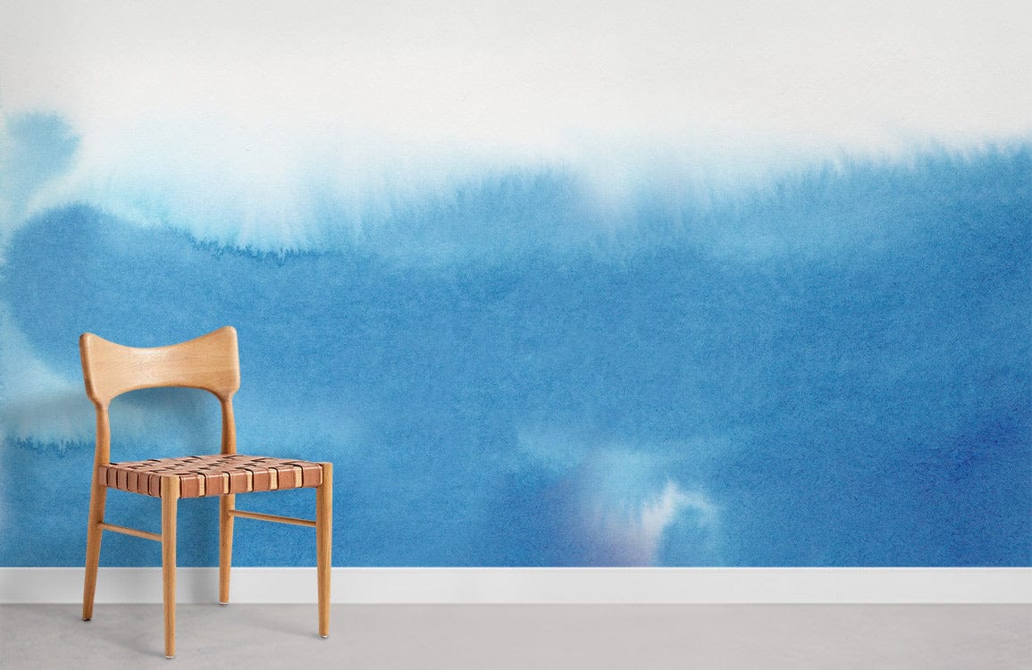 Serene Blue Watercolour Ombre Mural Wallpaper with wooden chair, grey flooring in modern living room.