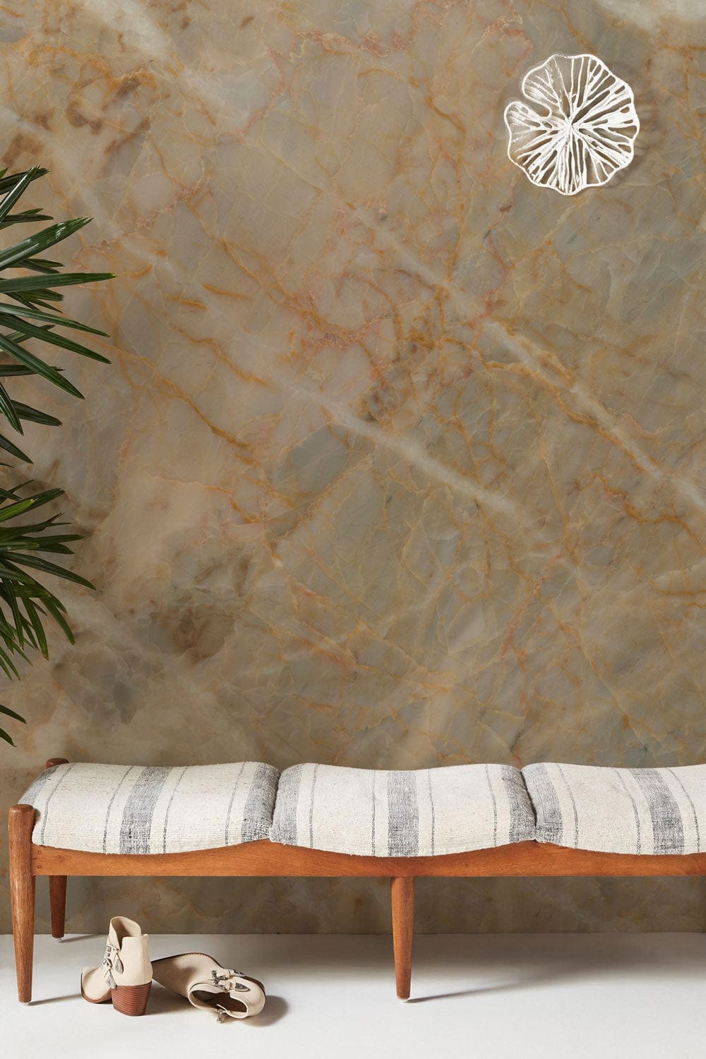 Elegant wallpaper with a natural stone effect, earthy marble tones, featuring a striped bench and shoes.