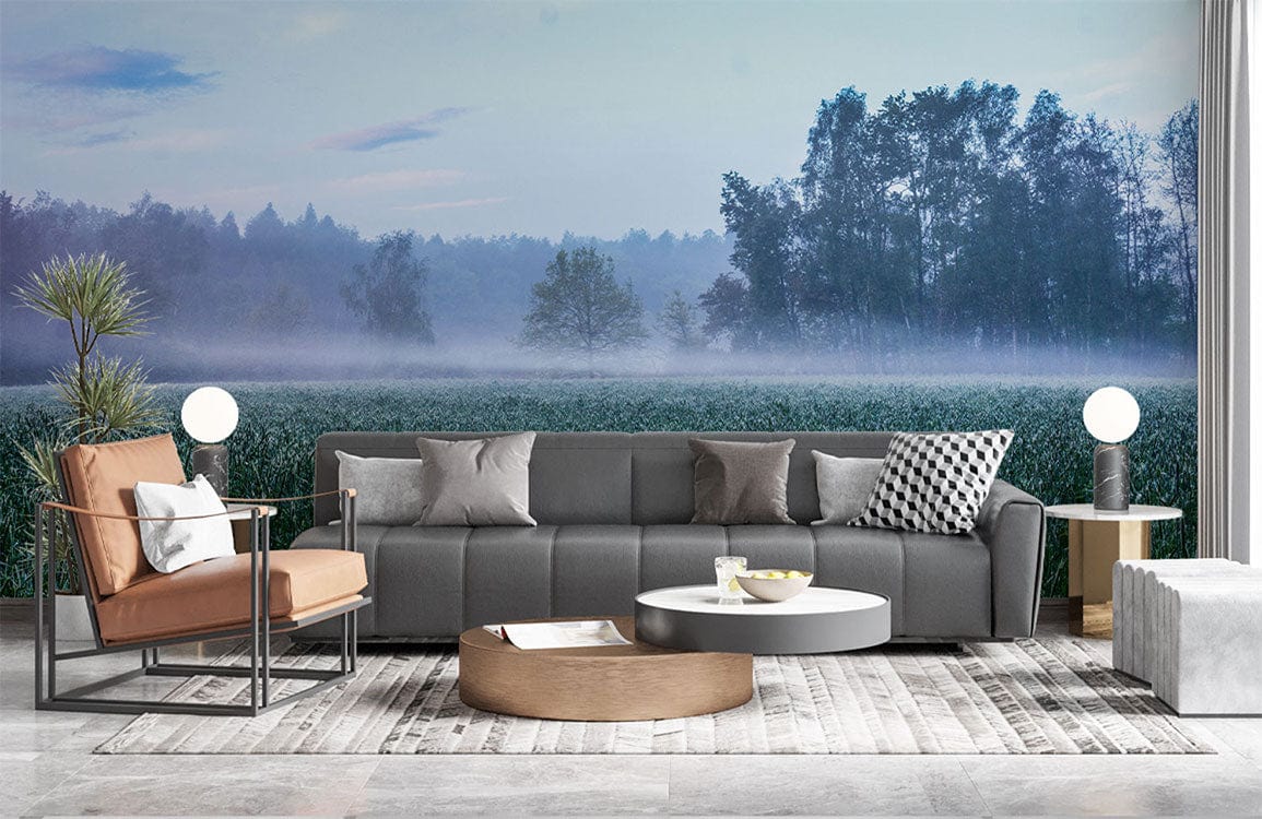 Tranquil misty forest wallpaper in living room; grey sofa, modern armchair, patterned rug, ambient lighting.