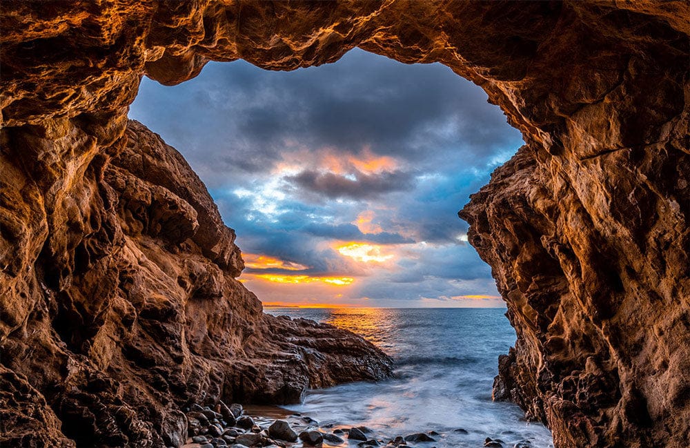 Stunning Ocean Cave Sunset Mural Wallpaper in Vibrant Coastal Colours