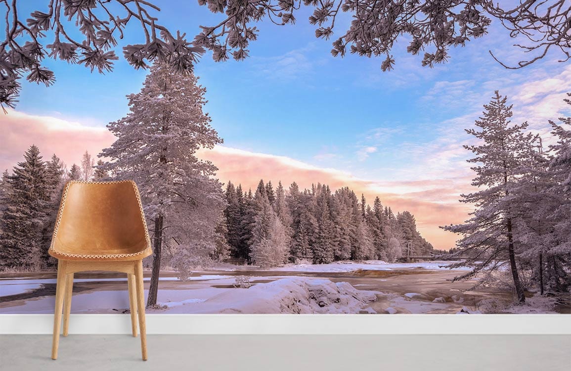 Enchanting snowy forest mural wallpaper with brown chair, white wall, serene pastels, and wooden flooring.