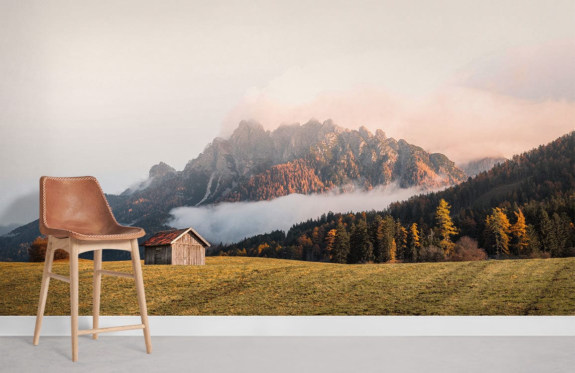 Serene Autumn Mountain Landscape Mural Wallpaper, rustic cabin, warm tones, brown chair, grey floor.