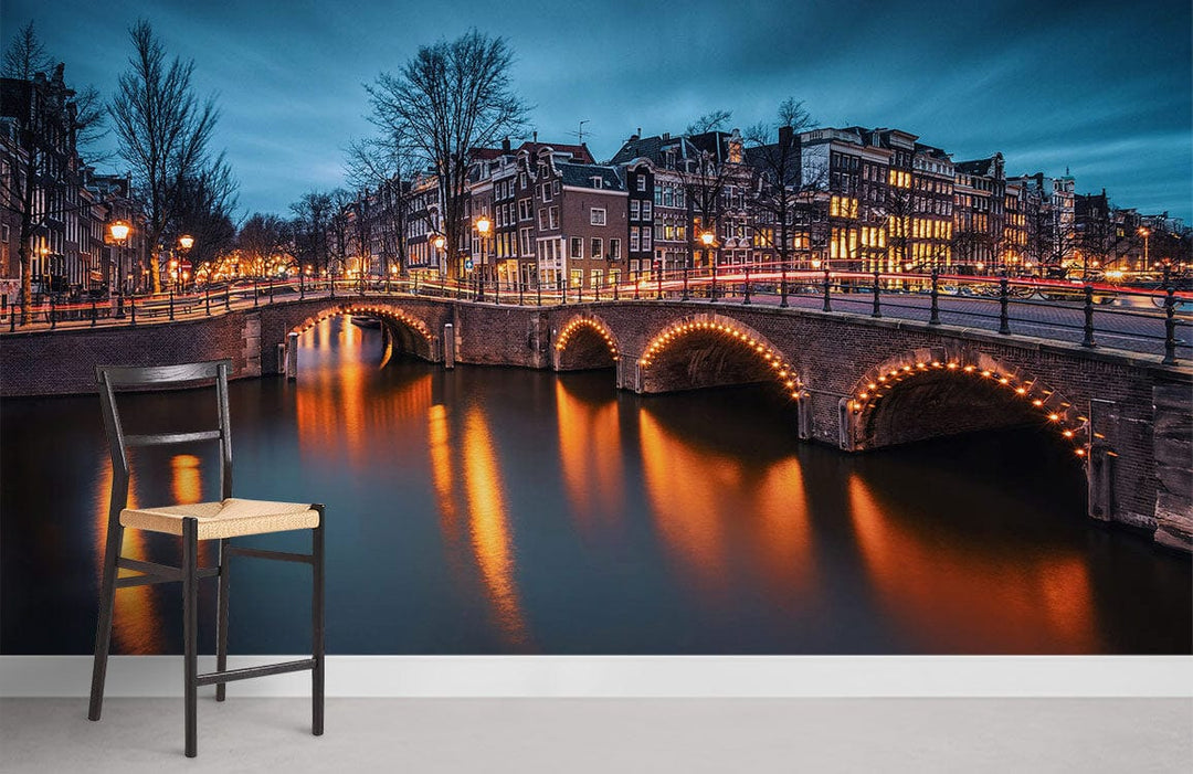Enchanting Amsterdam canal mural with chair, blue tones, warm lights; modern wallpaper in living room.