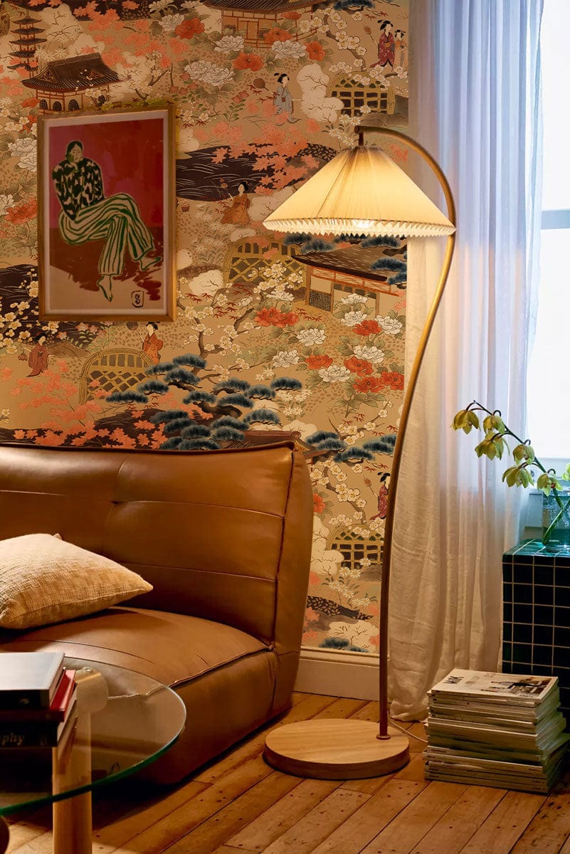 Japanese-inspired mural wallpaper with earthy tones, brown leather sofa, wooden floors, and elegant lamp.
