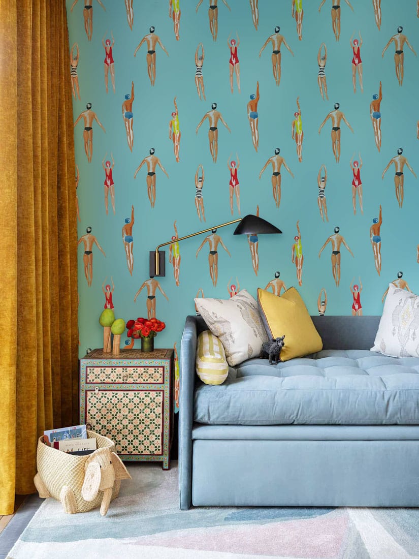 Retro Swimmers aqua blue wallpaper decor with modern armchair, vibrant mustard curtains, geometric bedside table.