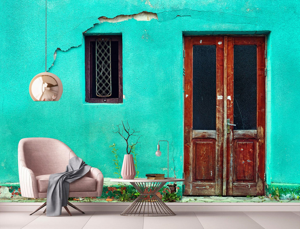 Vintage teal mural with rustic wood door accents, pink armchair, modern pendant light, tiled floor.