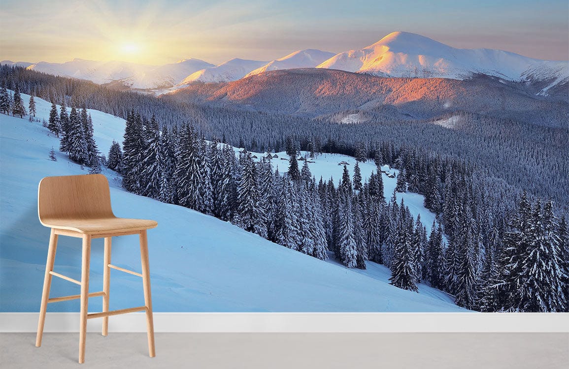 Tranquil Snowy Mountain Sunrise Mural Wallpaper with wooden stool, peaceful winter landscape wall decor.
