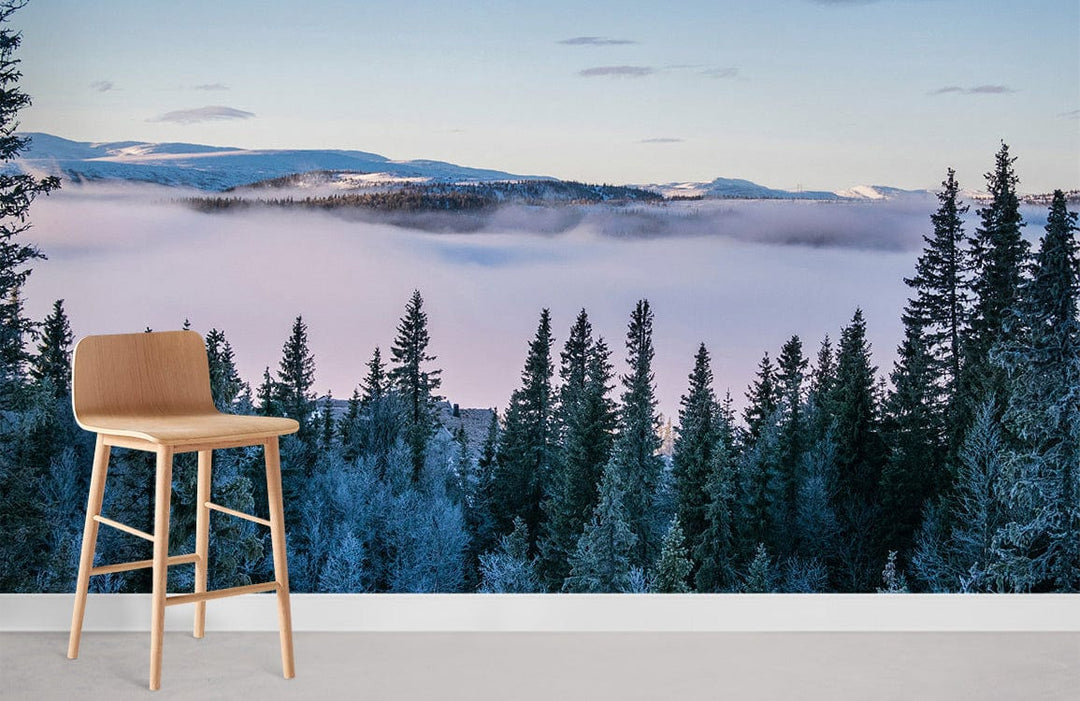 Mist-covered forest mural wallpaper with frosty mountain design; wooden stool, minimalistic modern room setting.