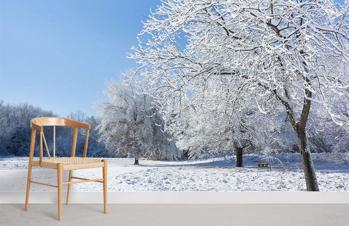 Snowy forest mural wallpaper with wooden chair, blue sky, in minimalist room with grey flooring.