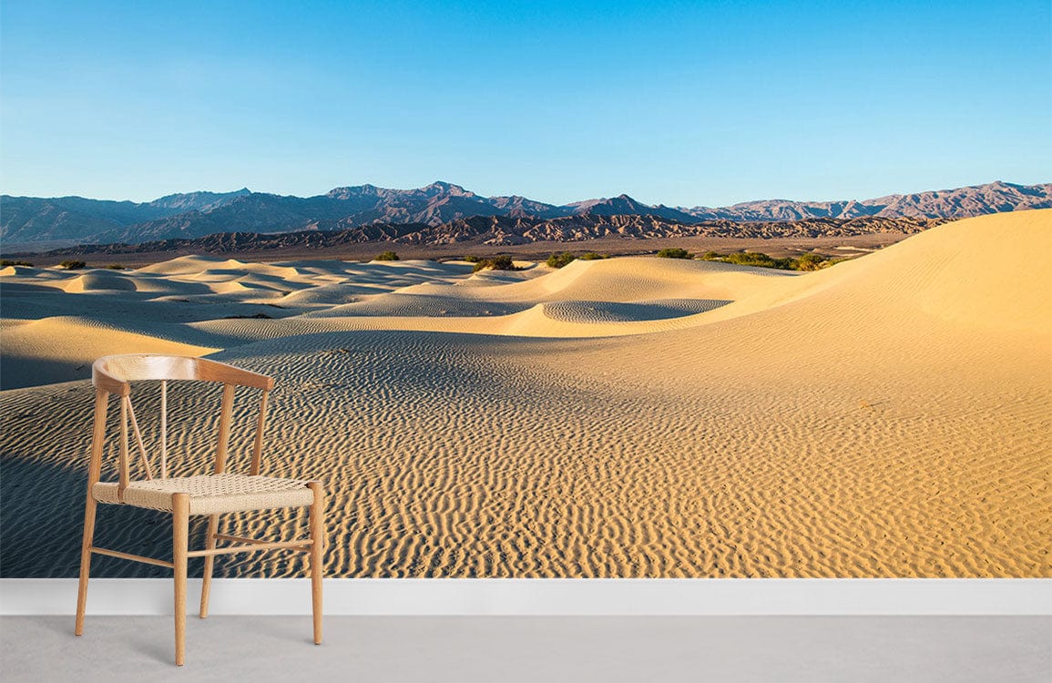 Desert panorama mural wallpaper with chair, concrete flooring, golden dunes, blue sky in modern setting.