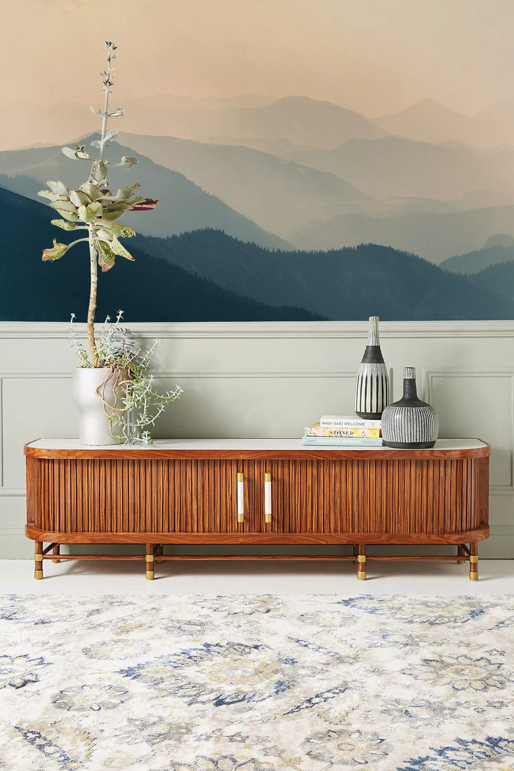 Serene Misty Mountain Range wallpaper with vintage sideboard, neutral rug, and soft green wall panelling.
