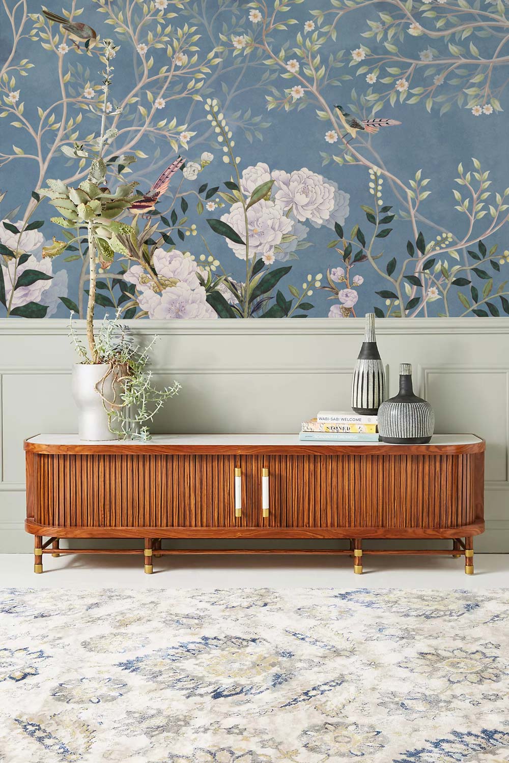 Tranquil Blue Floral Bird Garden Wallpaper with elegant wooden sideboard, patterned rug, and nature decor.