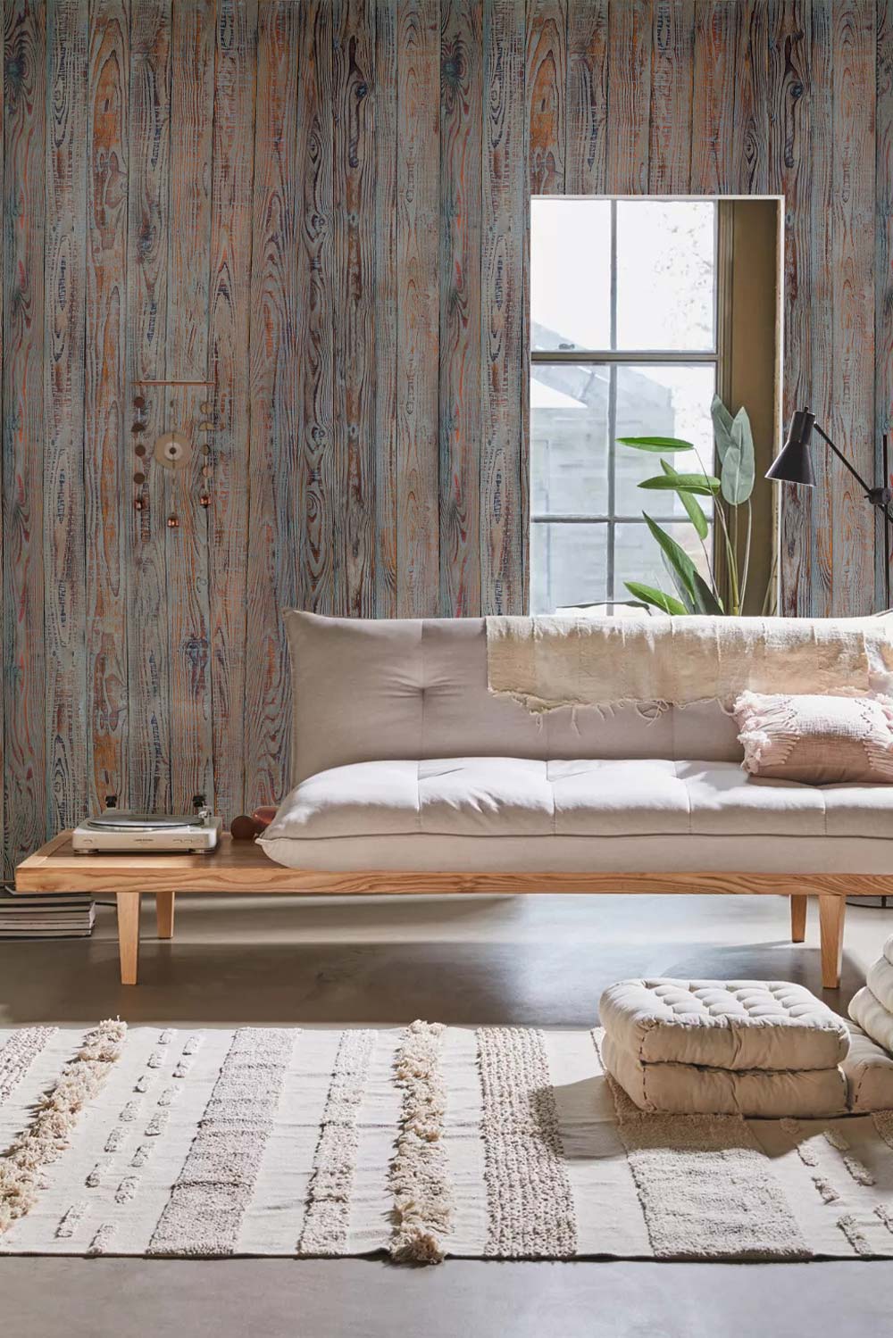 Rustic grey-brown wood mural wallpaper with modern beige sofa, cosy rug, and wood flooring in living room.