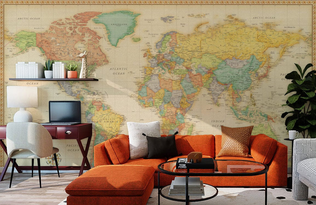 Vintage World Map Mural Wallpaper with antique earth tones, orange sofa, and dark wood desk in study.