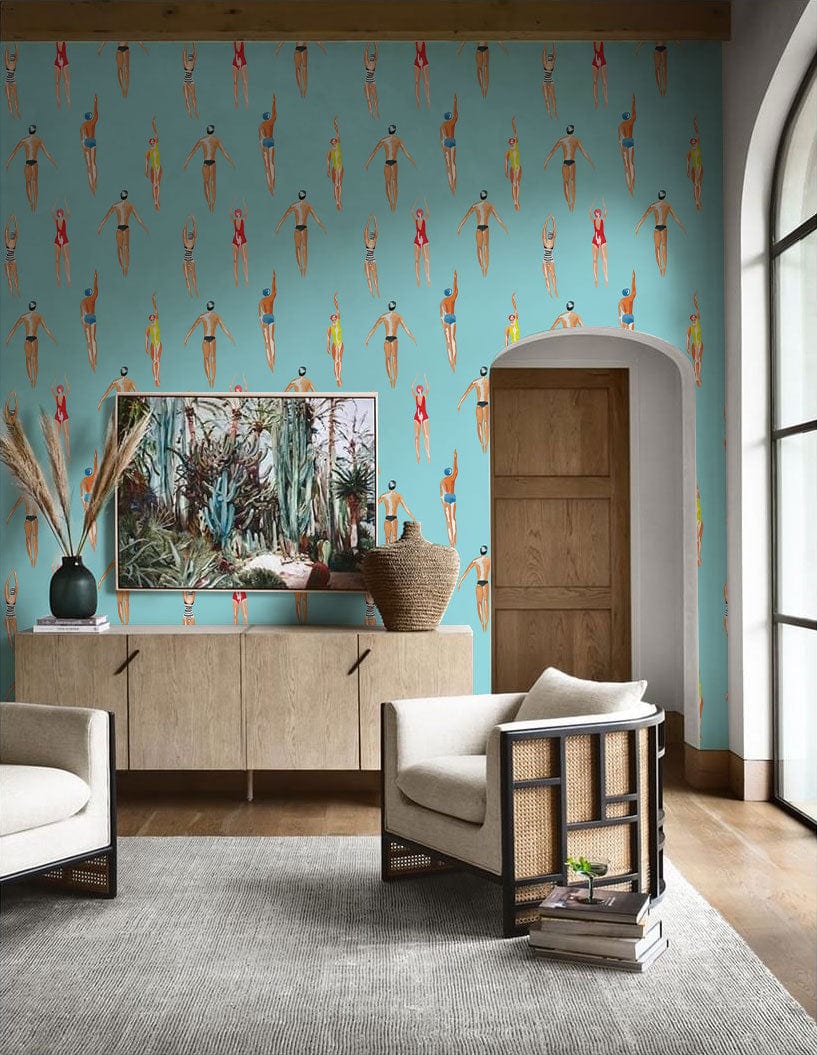 Retro Swimmers aqua blue wallpaper in living room, beige armchairs, wooden floor, stylish decor.