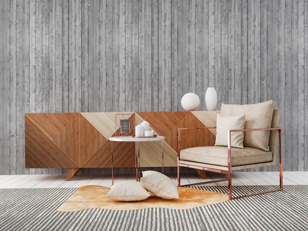 Rustic grey wood plank wallpaper with geometric sideboard, beige chair, striped rug in modern sitting room.