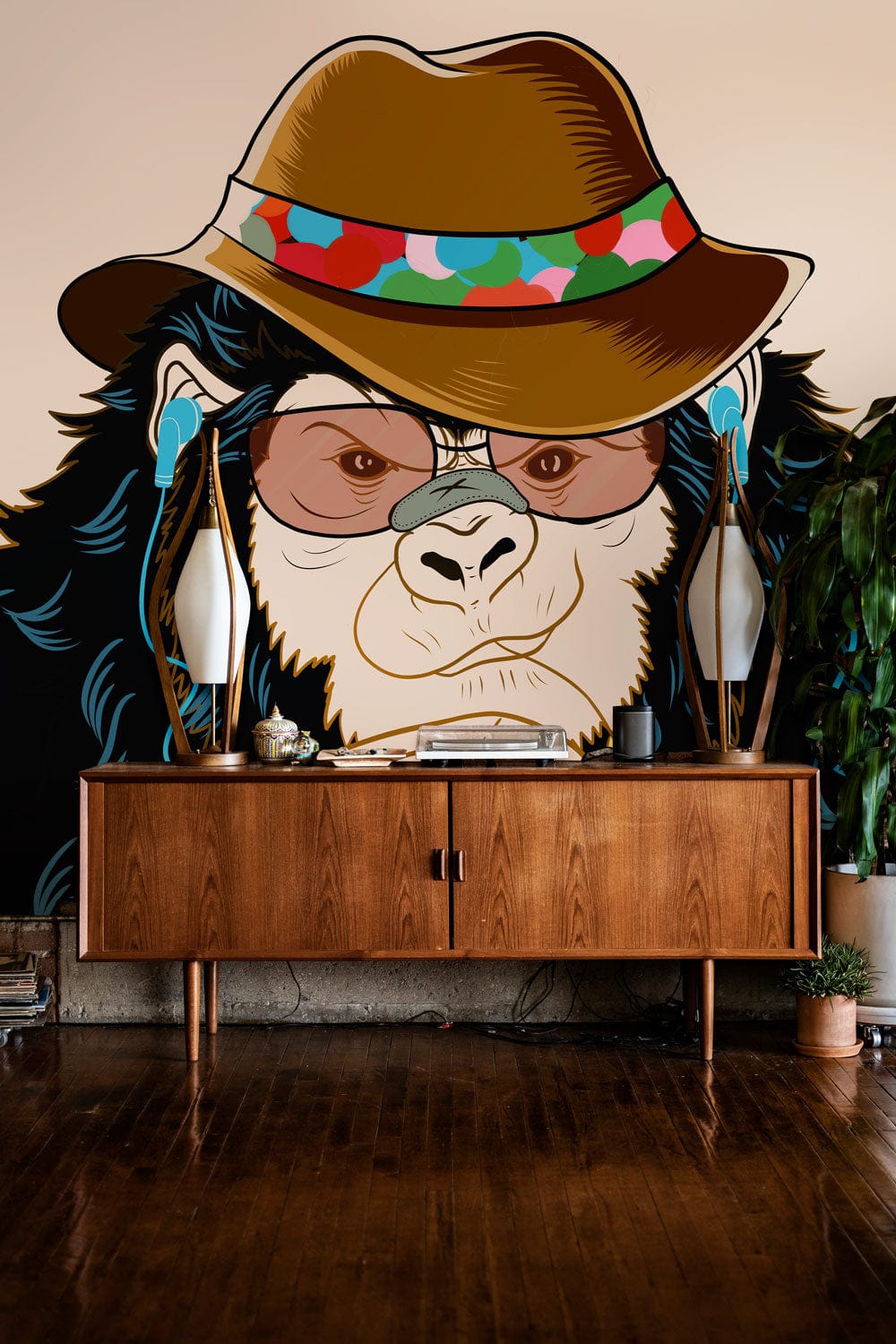 Chic Monkey mural wallpaper featuring brown hat, glasses; wooden sideboard; brown hardwood flooring; living room.