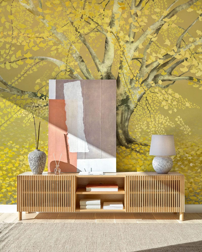 Golden Autumn Tree Mural Wallpaper in living room with wooden console, modern lamp, and textured rug.