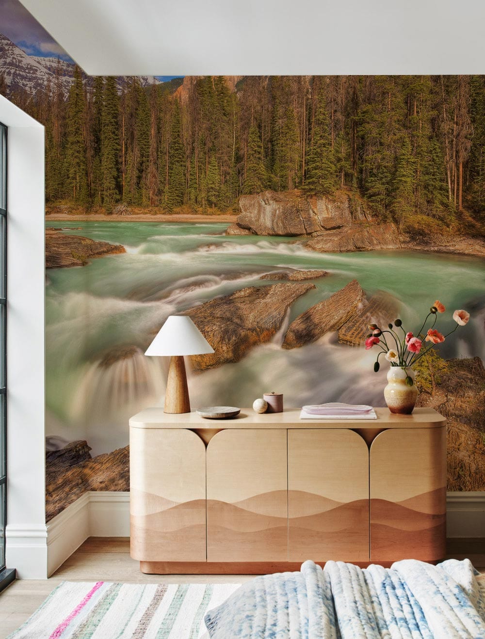 Majestic mountain river mural wallpaper, earthy tones, wooden sideboard, cosy room, modern neutral decor.
