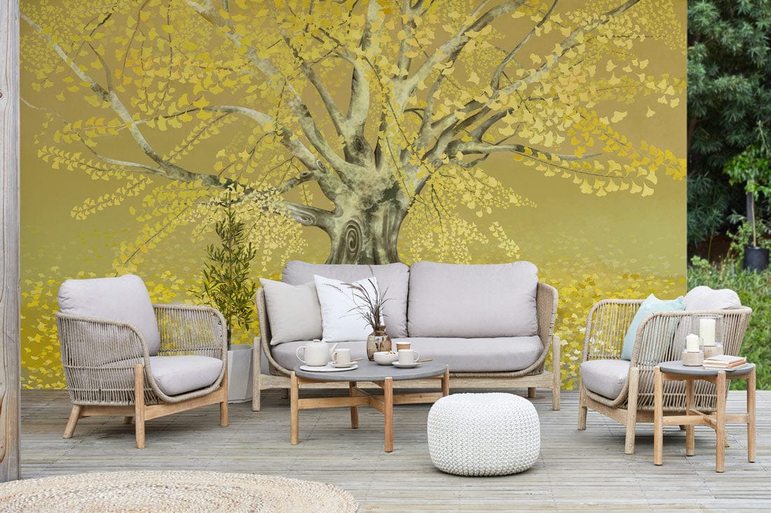 Golden Autumn Tree Mural Wallpaper in living room with beige sofa, wooden flooring, and wicker chairs.