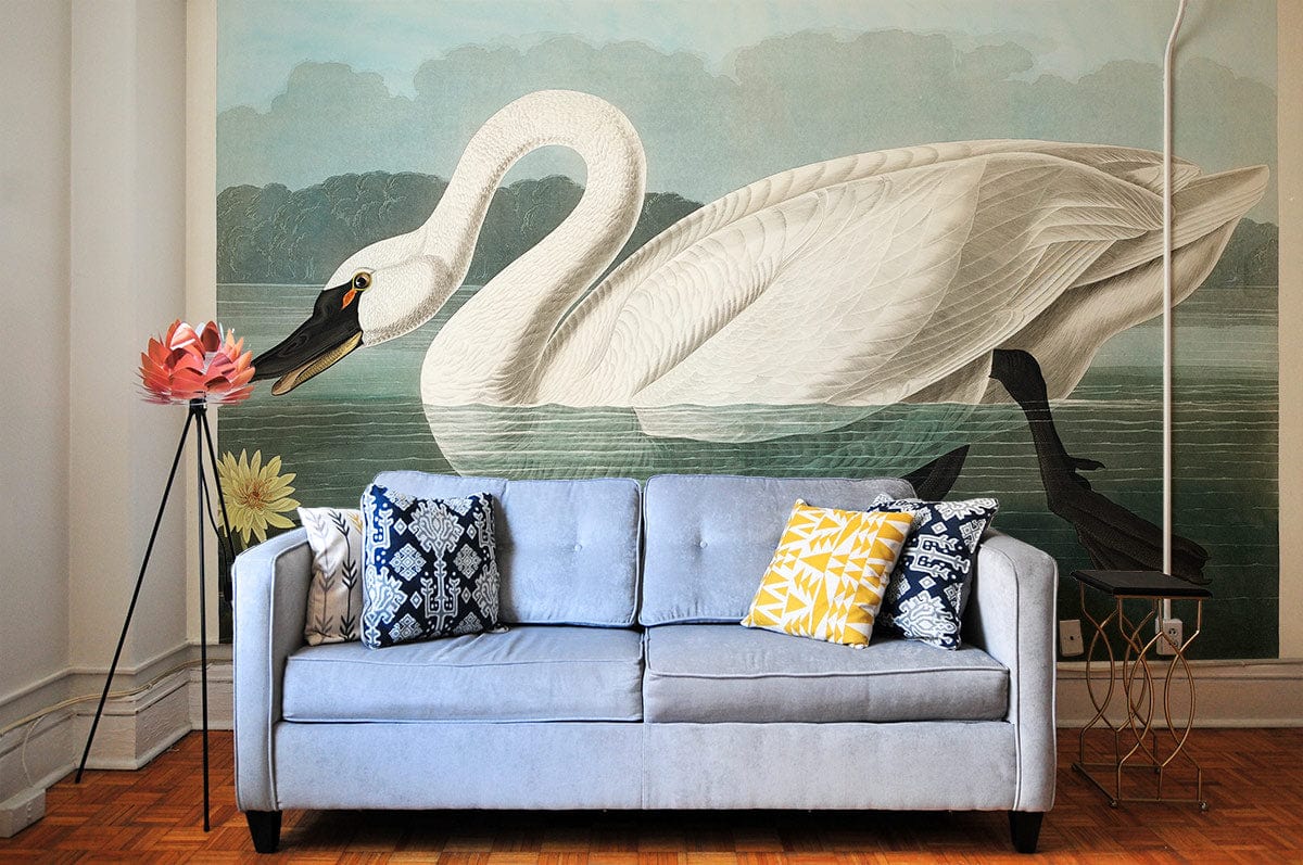 Alt text: Vintage swan mural wallpaper with blue sofa, parquet flooring, decorative cushions; elegant living room setting.