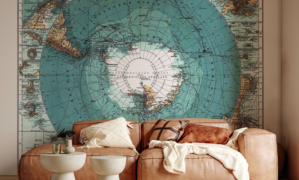 Vintage World Map Aqua Blue Mural Wallpaper in living room with tan leather sofa, round tables.