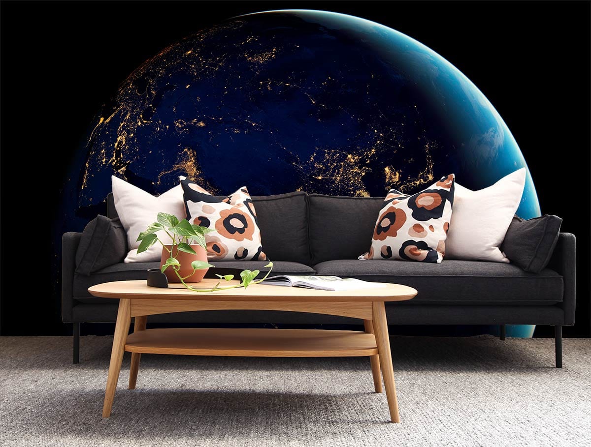 Cosmic Midnight Blue Earth View Mural Wallpaper, dark sofa, wooden coffee table, grey carpet.