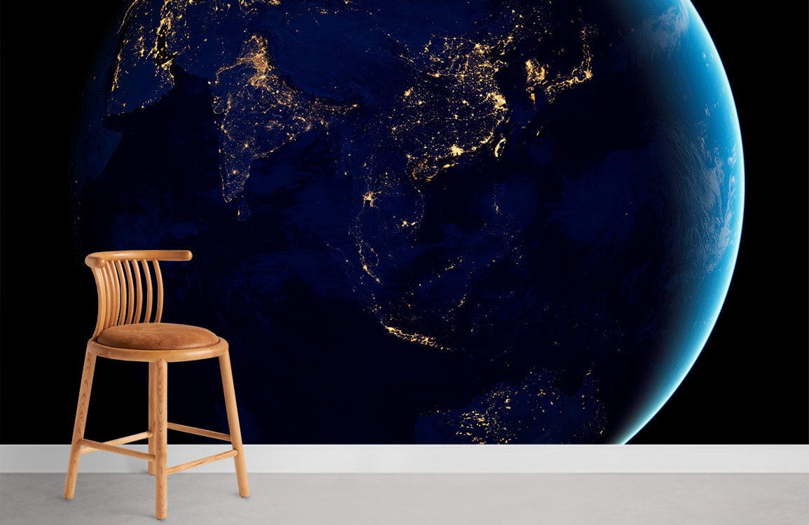 Cosmic Midnight Blue Earth Mural Wallpaper with chair, concrete flooring in modern room setting.