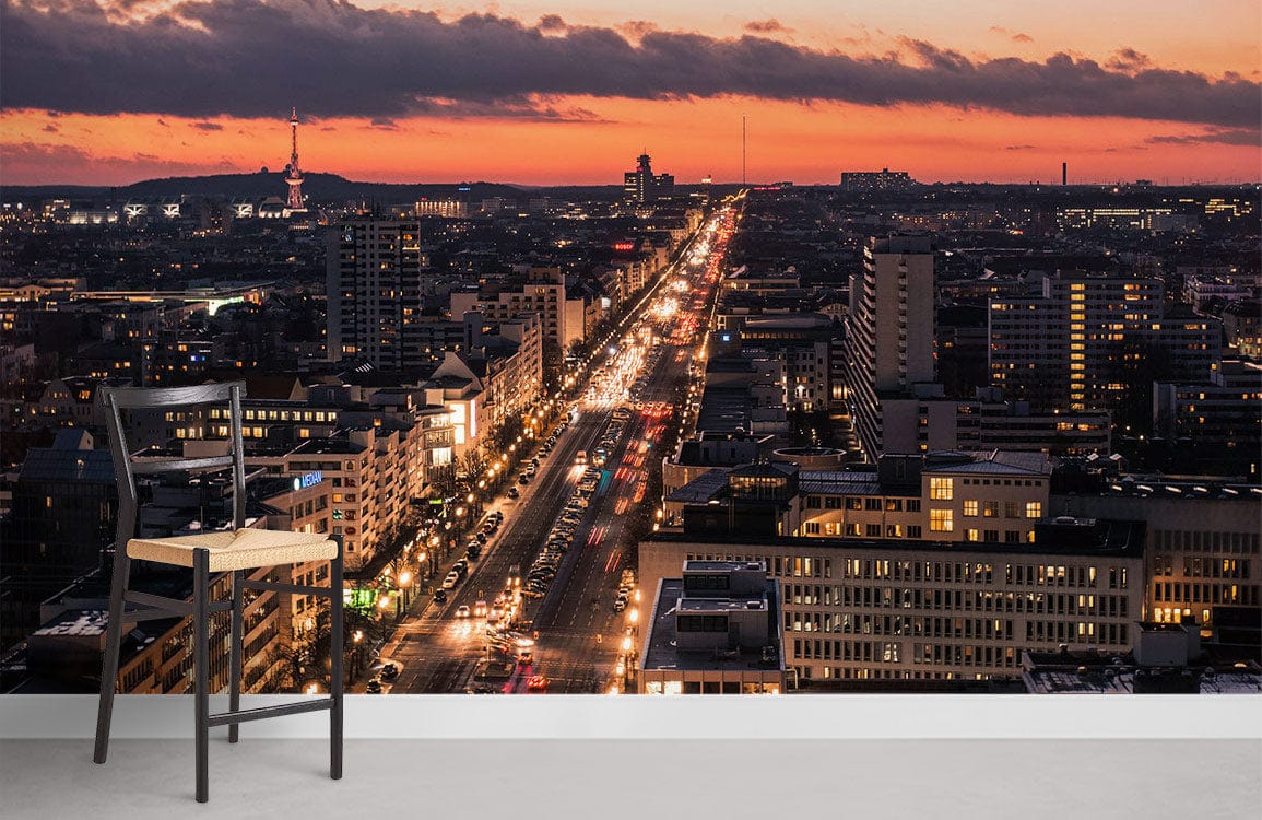 Vibrant urban sunset cityscape mural wallpaper with chair; grey flooring in modern room setting.