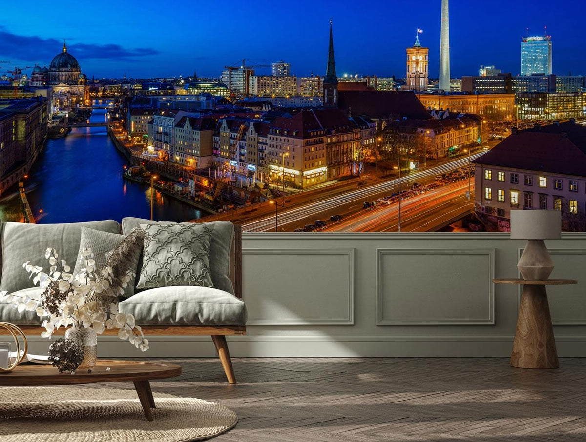 Berlin night skyline mural wallpaper, grey sofa, wooden flooring, light panelled wall, modern decor.